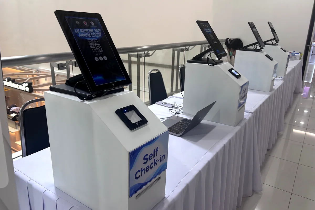 ตู้ Self Check-in ด้วยตนเองหลายจุดในงานประชุม หน้าจอแสดง QR Code พร้อมเครื่องสแกนและโน้ตบุ๊กควบคุม